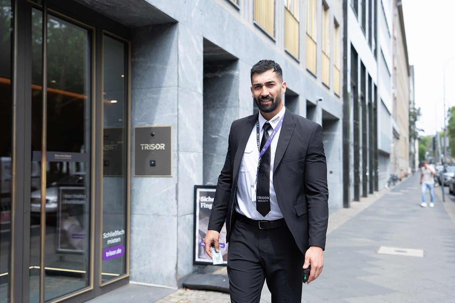MOGROUP security officer in a suit outside a TRISOR location